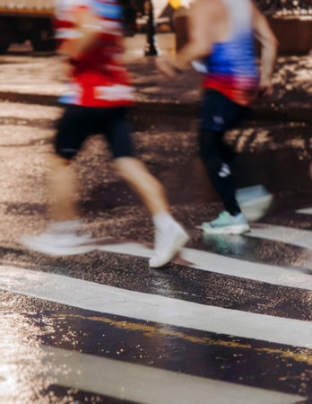 Night marathon runners crowd in the rain, sportsmen participants start running the half-marathon in...