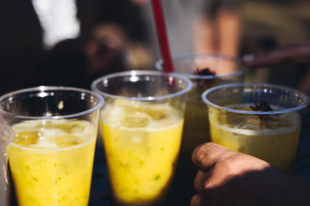 Barman mixing liquor beverages and alcohol drinks in plastic cups, bartender working, beautiful row...