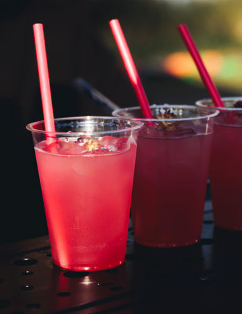Bartender working, beautiful row line of different colored cocktails on open air summer party in a...