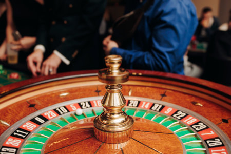 Casino table with roulette wheel in motion, with casino chips, tokens, the hand of croupier, dollar...