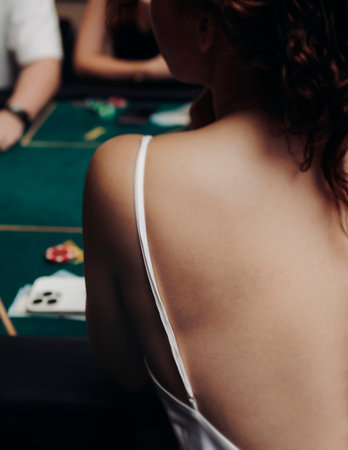 Casino table with roulette wheel in motion, with casino chips, tokens, the hand of croupier, dollar...