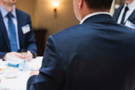 Group of men in business suits talking and discussing during coffee break at conference, politicians...