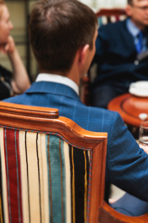 Group of men in business suits talking and discussing during coffee break at conference, politicians...
