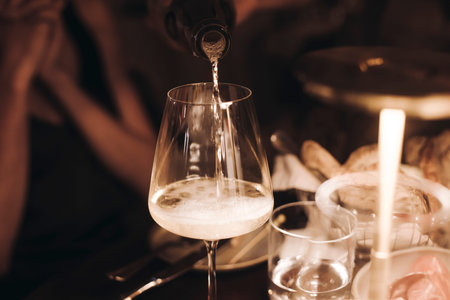 Group of guests celebrate and raise glasses, toasting and cheering with alcohol glasses with wine...