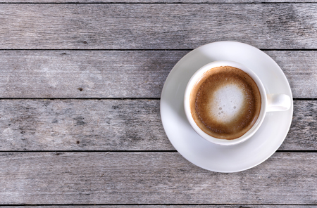Cappuccino White coffee cup on old wood floor Vintage, top view.の写真素材