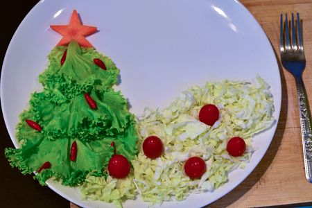 Christmas tree made of lettuce on a white dish.の写真素材