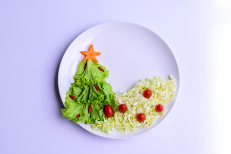 Christmas tree made of lettuce on a white dishの写真素材