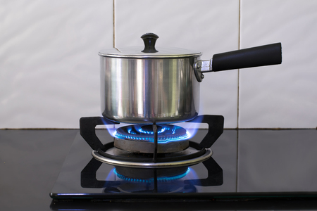 Metal pot on the flame gas stove for boiling water Soup.の写真素材
