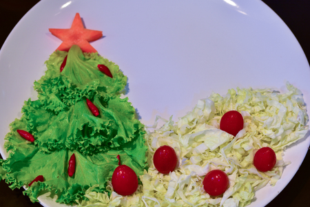 Christmas tree made of lettuce on a white dishの写真素材
