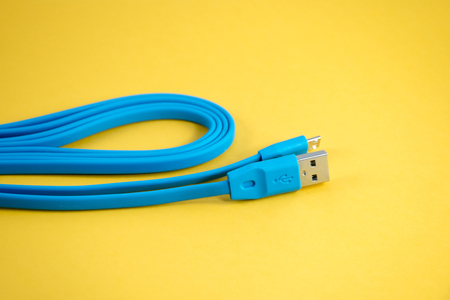 USB blue cable  for mobile phone on yellow background.の写真素材