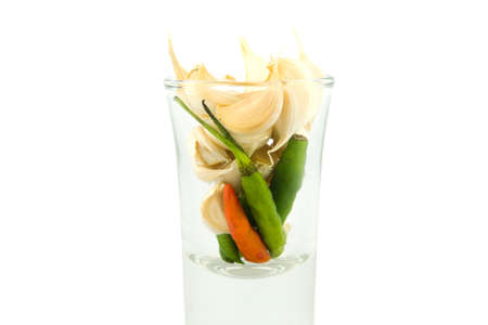 Garlic and Chili Peppers in shot glassの写真素材