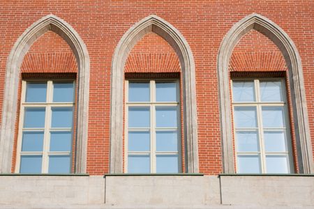 Three high glassed white-framed windows in a red brick wallの写真素材