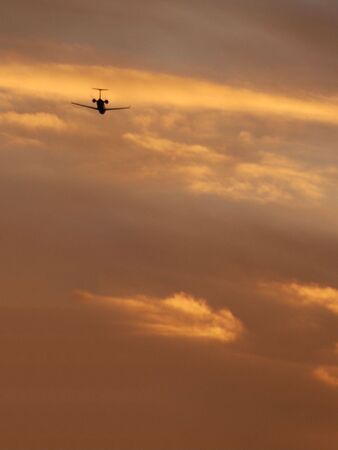 A beautiful image of a plane against the golden skyの写真素材