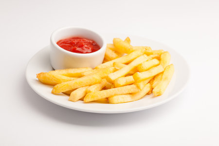 A beautiful photo of a closeup menu of fresh delicious french fries sauce on a plate on a white backgroundの写真素材