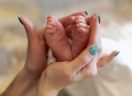 close-up of mother's hands and baby's little feetの写真素材