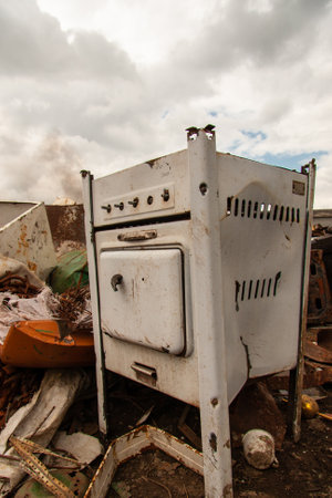 rusty old gas stove on scrap metal in the open airの写真素材