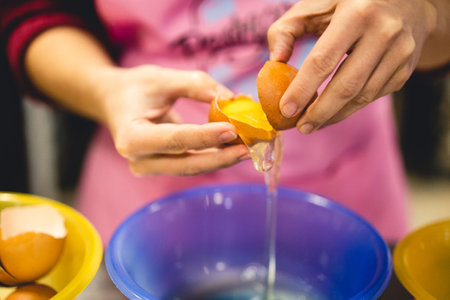 the cook breaks the egg in the kitchen preparing a delicious mealの写真素材