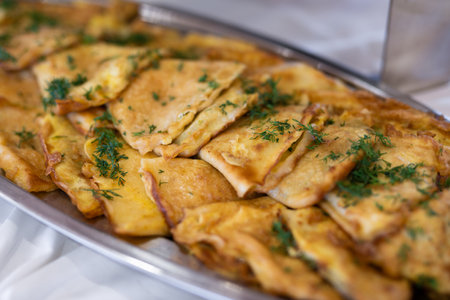 delicious triangular pancakes with greens laid out on a plate