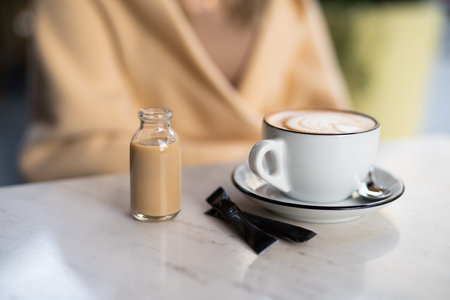 a fragrant and warm mug of cappuccino with a drawing heart, girl hold in hands