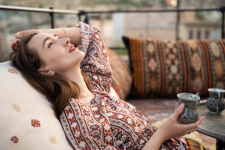 beautiful girl is relaxing with a cup of tea on the sofa