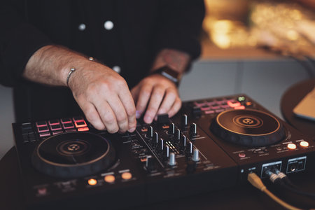a DJ plays music on a controller at a partyの写真素材