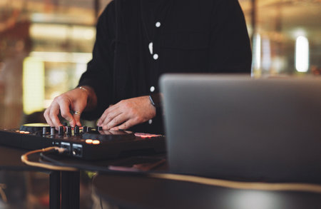 a DJ plays music on a controller at a partyの写真素材