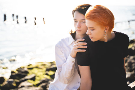 two lovers boy and girl are happy walking and hugging on the sandy beach near the seaの写真素材