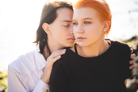 two lovers boy and girl are happy walking and hugging on the sandy beach near the seaの写真素材