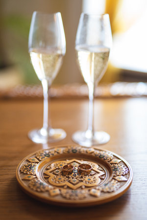 Champagne glasses and wedding rings on a traditional wooden plateの写真素材