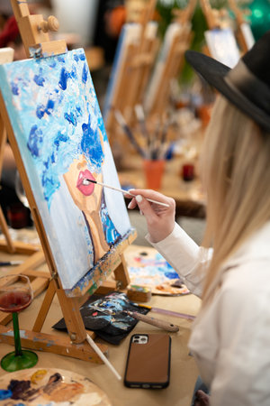 girl artist paints a picture on canvas with oil paints