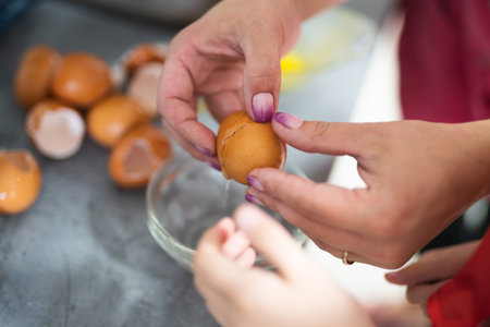 the cook breaks the chicken egg while preparing a delicious dishの写真素材