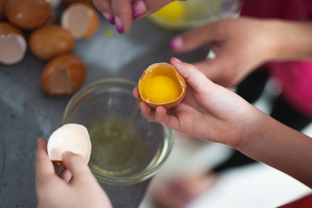 the cook breaks the chicken egg while preparing a delicious dishの写真素材