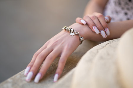 close-up of a girl's hand with a beautiful manicure and a jewelry bracelet on her handの写真素材