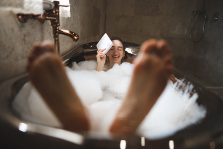 beautiful sexy girl in a bubble bath reading a book, funny with big feet
