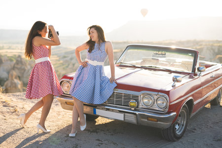 two beautiful girl in a retro dress are photographed on camera on mountain landscape in Cappadocia...