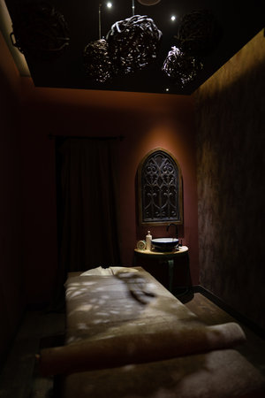 dark interior of a massage room with a table and dimmed lightsの写真素材