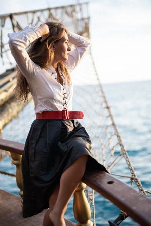 a beautiful girl in a pirate costume on the deck of a shipの写真素材