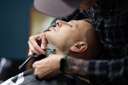 a man gets a haircut and a shave in a barbershopの写真素材