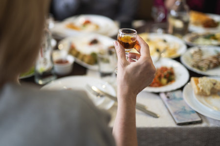 a person holding a glass with an alcoholic drink in his handsの写真素材