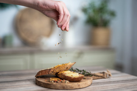 pour seasoning on a sandwich with butter on a wooden boardの写真素材