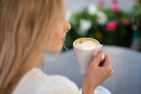 close-up of the face of a beautiful girl drinking coffeeの写真素材