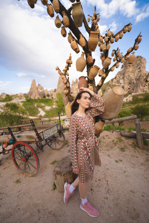 beautiful girl near a tree with jugs in the mountains of Cappadociaの写真素材