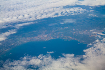 beautiful thick clouds in the sky from the height of the flight of the plane with a view of the continent and countriesの写真素材