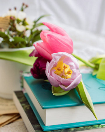 a beautiful arrangement of a bouquet of tulip flowers and a book