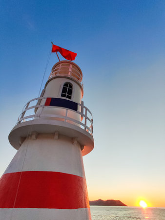 beautiful lighthouse tower on the coast at sunsetの写真素材