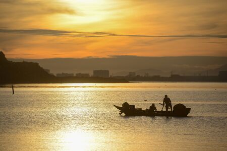 Silhouette fisherman fishing in sea in morning.の写真素材