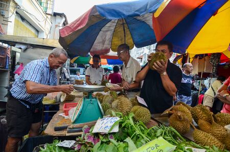 George Town, Penang/Malaysia - Jun 18 2016: A man smell the durian to determine which one to purchase.のeditorial素材