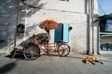 George Town, Penang/Malaysia - Jul 02 2016: A dog sleep beside the trishaw.のeditorial素材