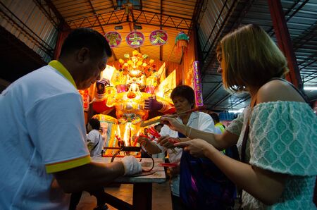 Bukit Mertajam, Penang/Malaysia - Aug 19 2016: Women burn joss stick and candle in front of hungry ghost statue.のeditorial素材