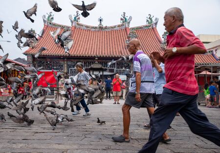 George Town, Penang/Malaysia - Aug 07 2016: Old man run at in front of chinese temple.のeditorial素材